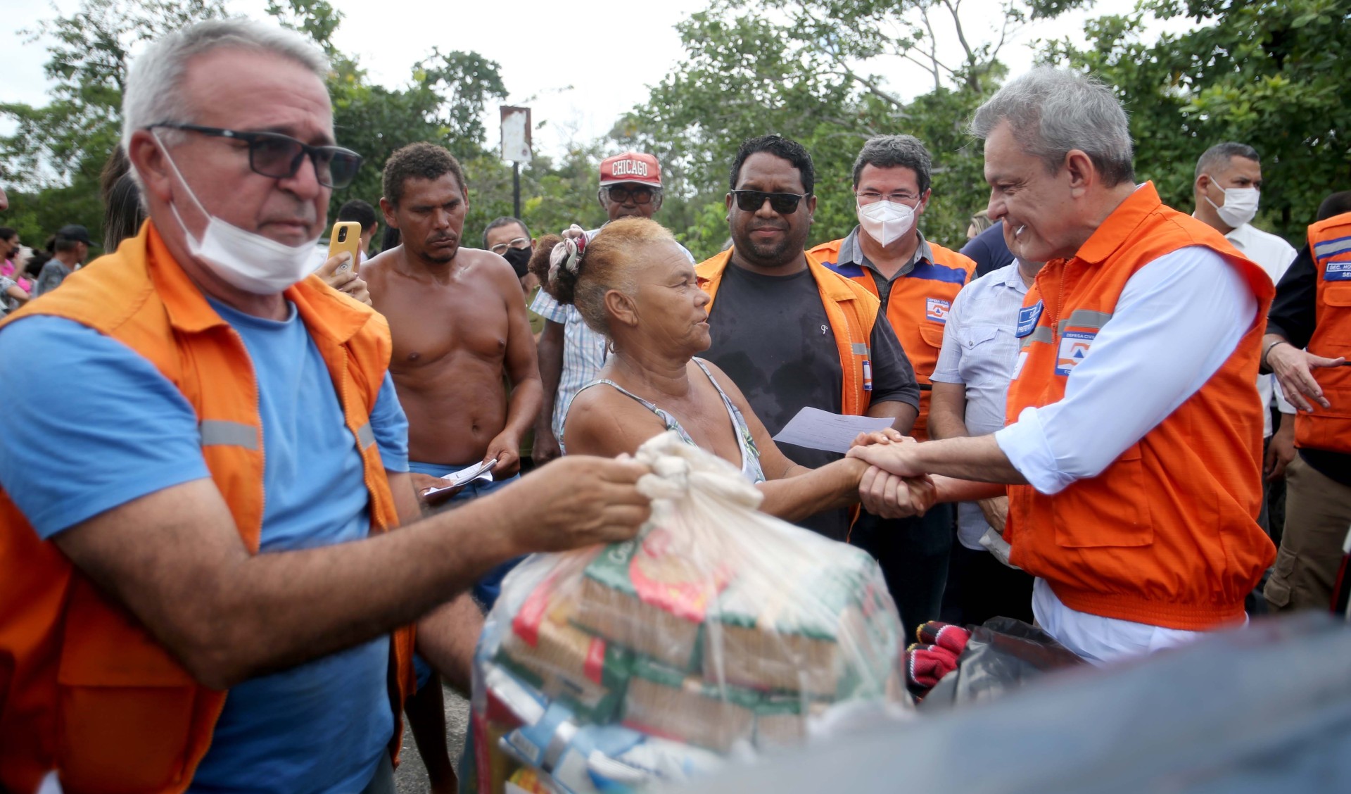 prefeito entrega um dos kits com material assistencial a uma senhora